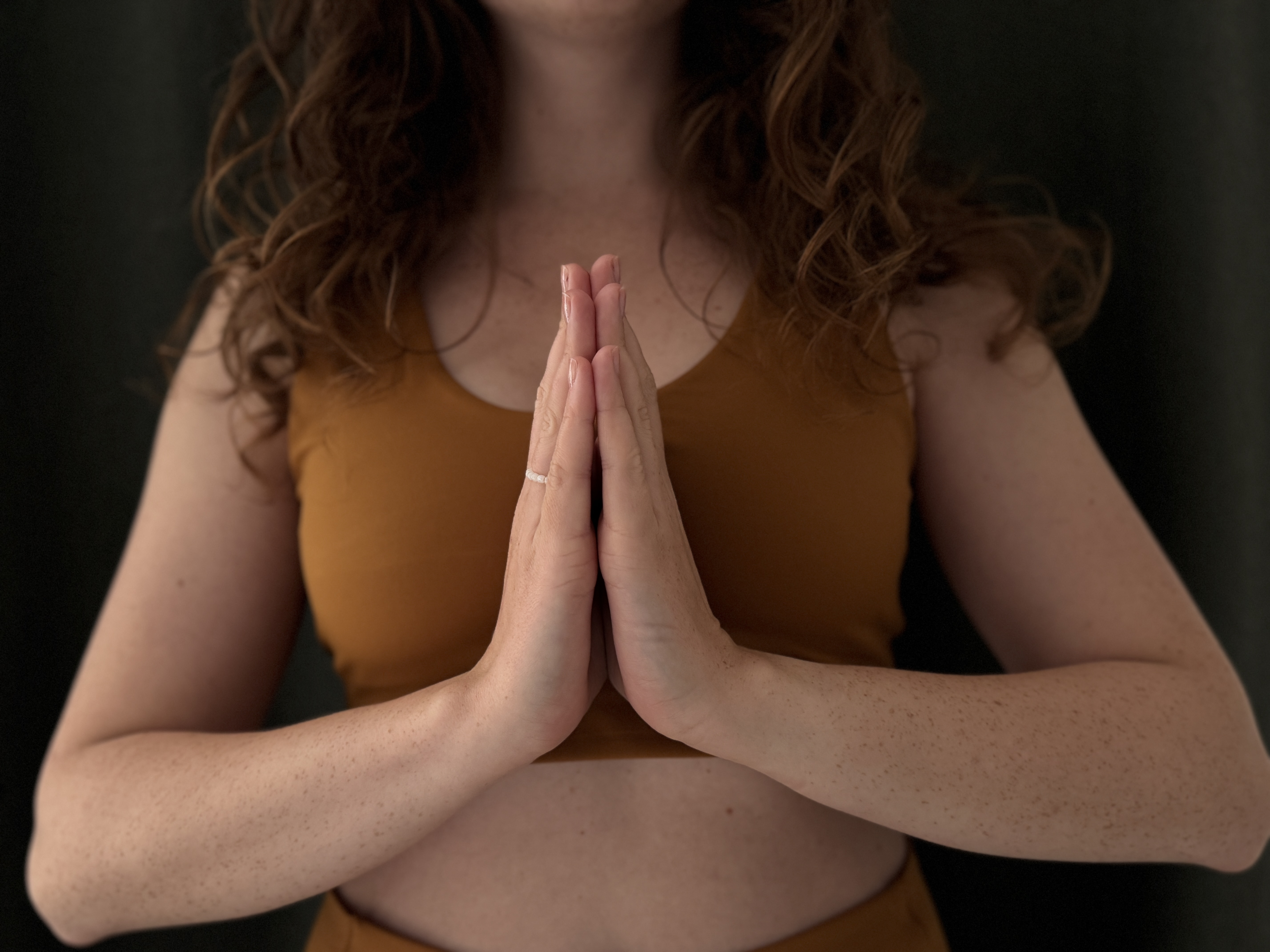 Gest namaste – złożone dłonie przy sercu i lekki skłon głowy